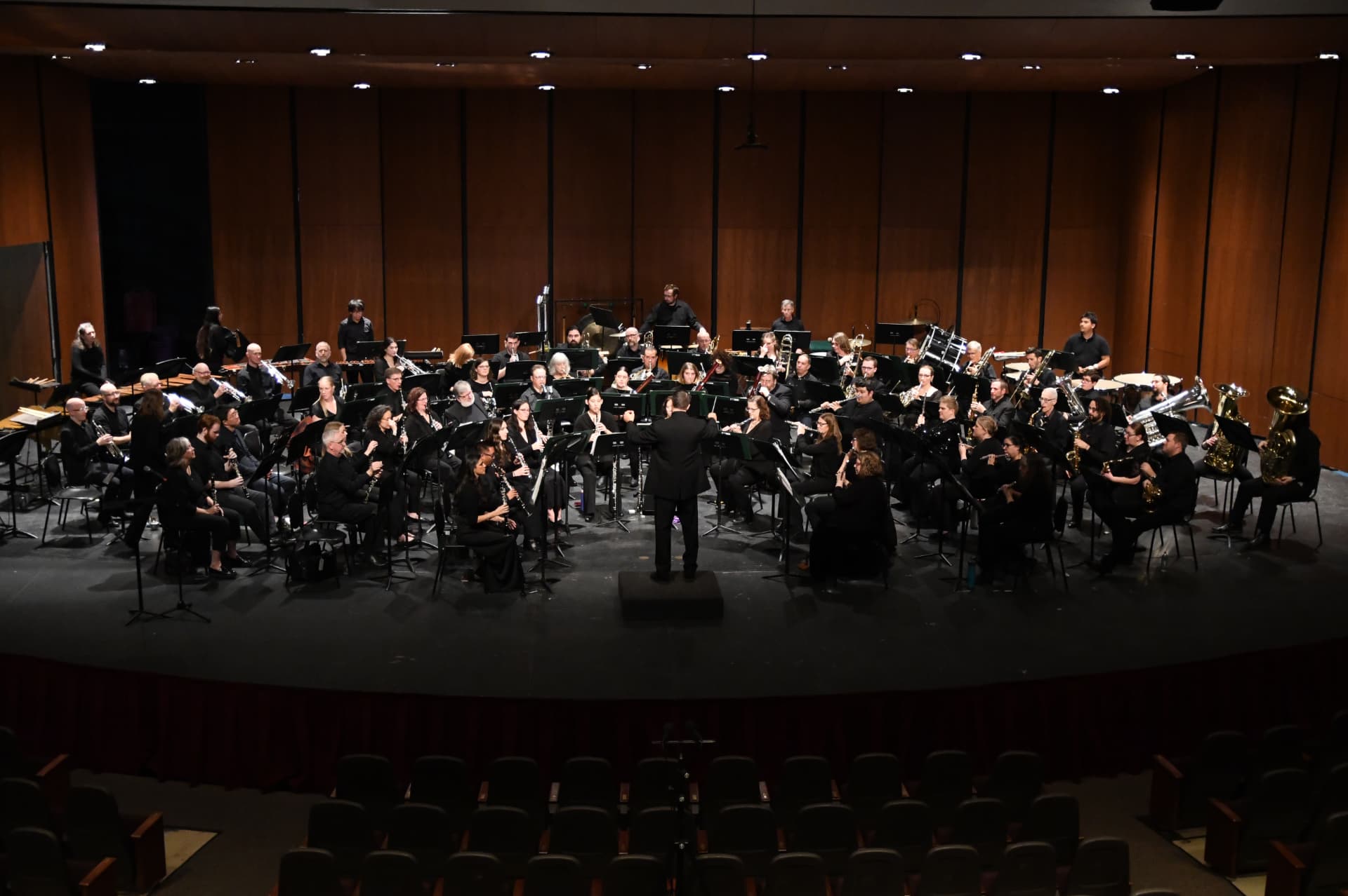 The full ensemble onstage together under warm stage light