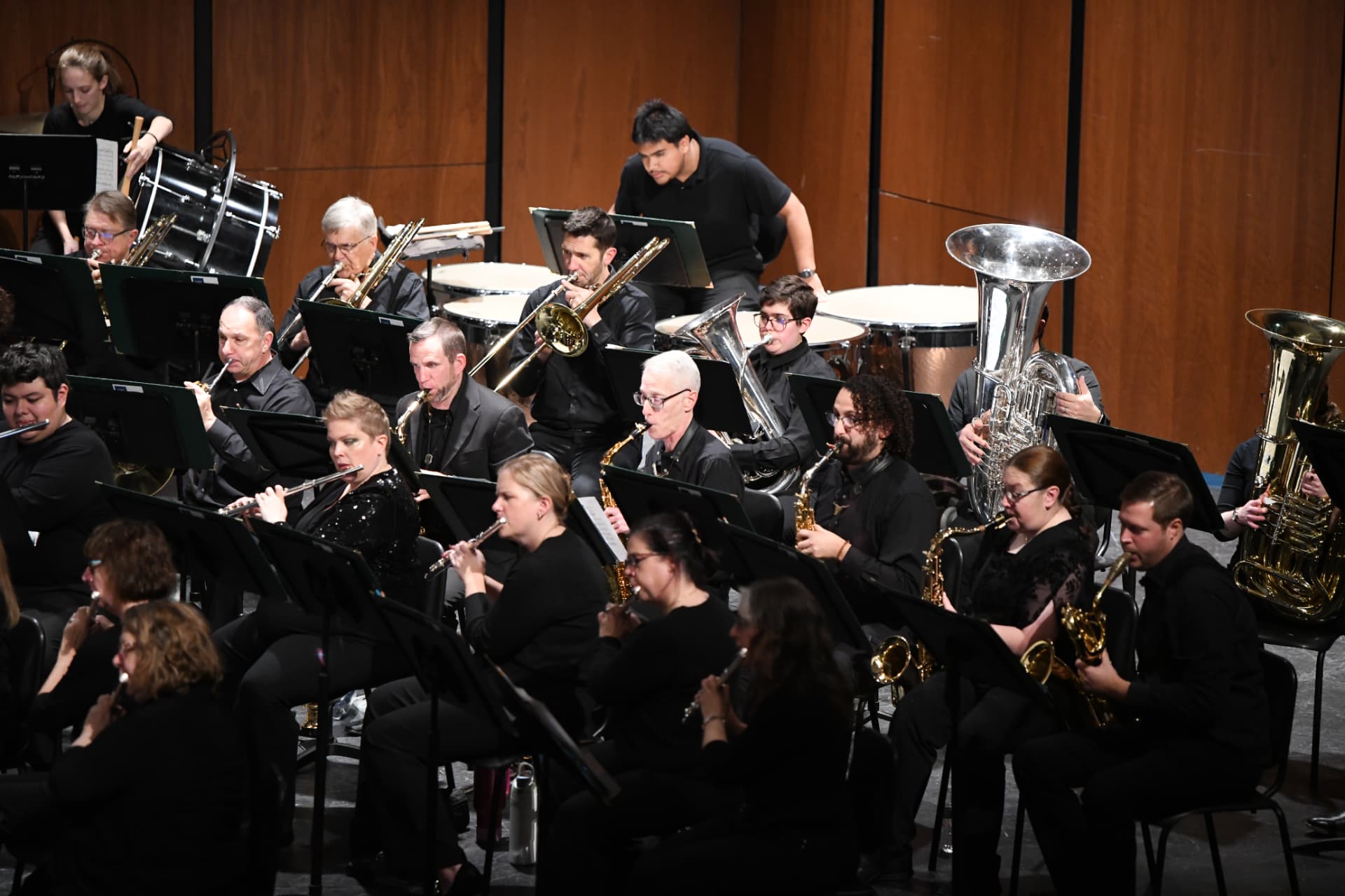 The brass and saxophone rows seen from above, instruments catching the stage light